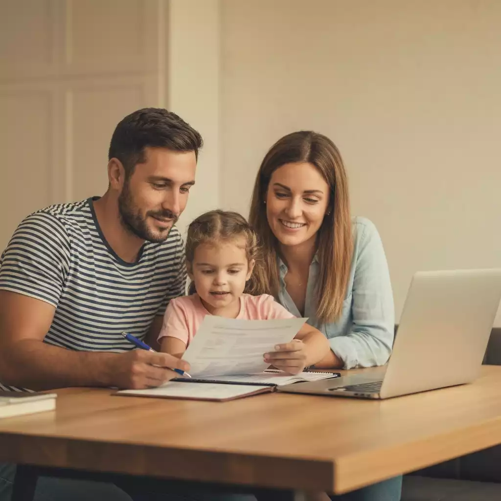 A family reviewing financial documents at a kitchen table, symbolizing financial planning for a home purchase